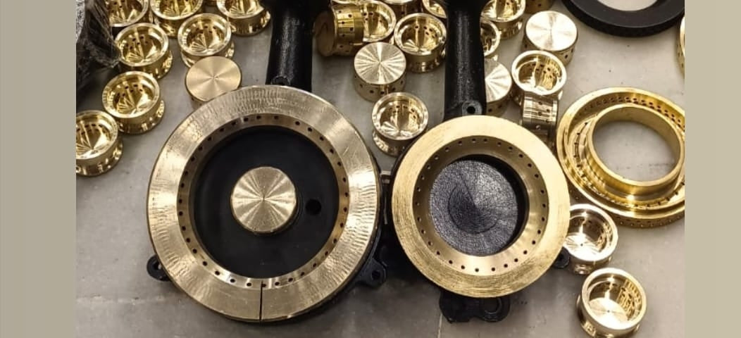 Collection of brass and black mechanical components on a gray surface