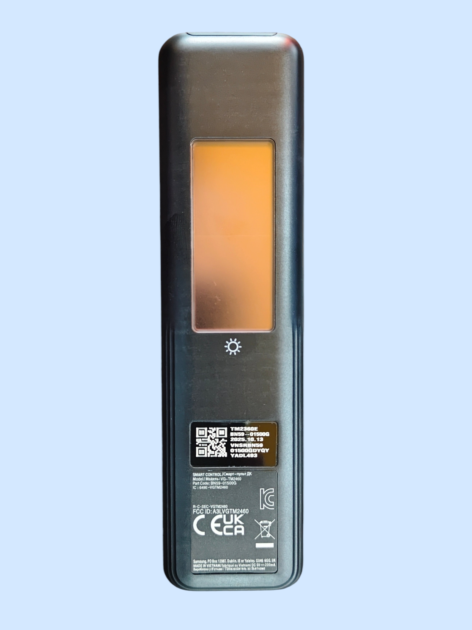 Rectangular electronic device with a glowing orange light on a light blue background