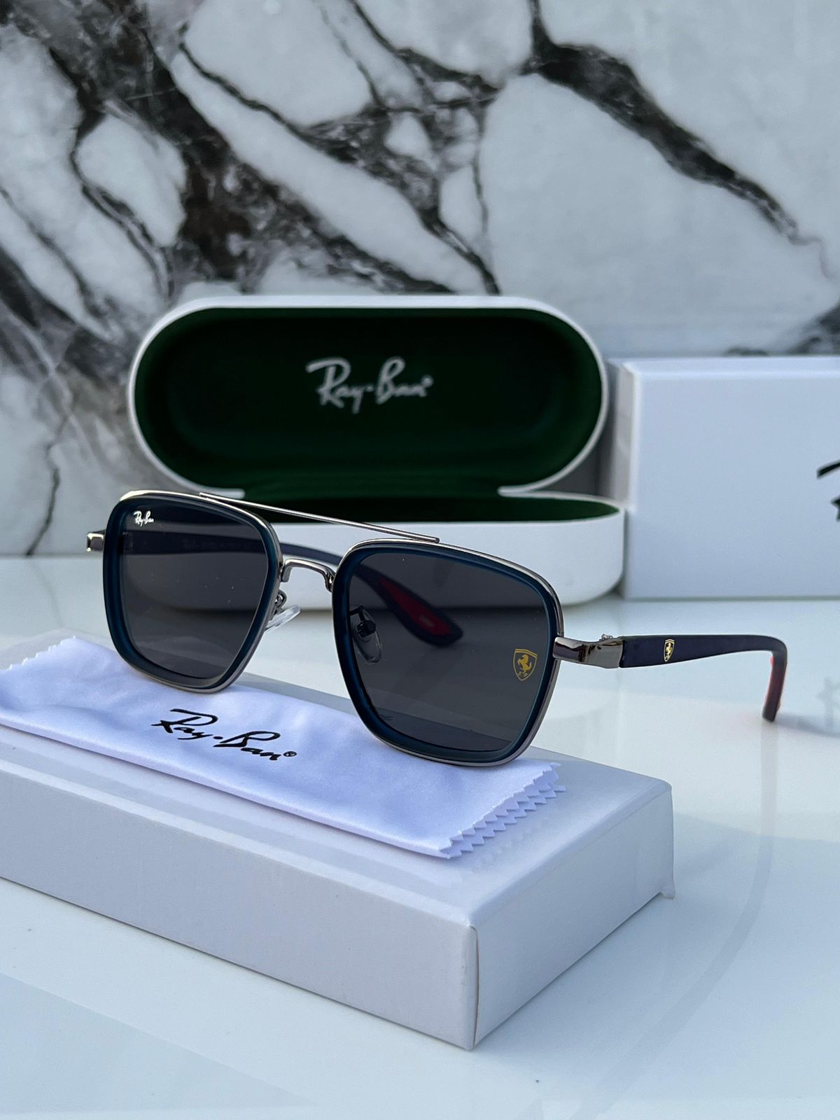 Ray-Ban sunglasses with case and box on a marble surface