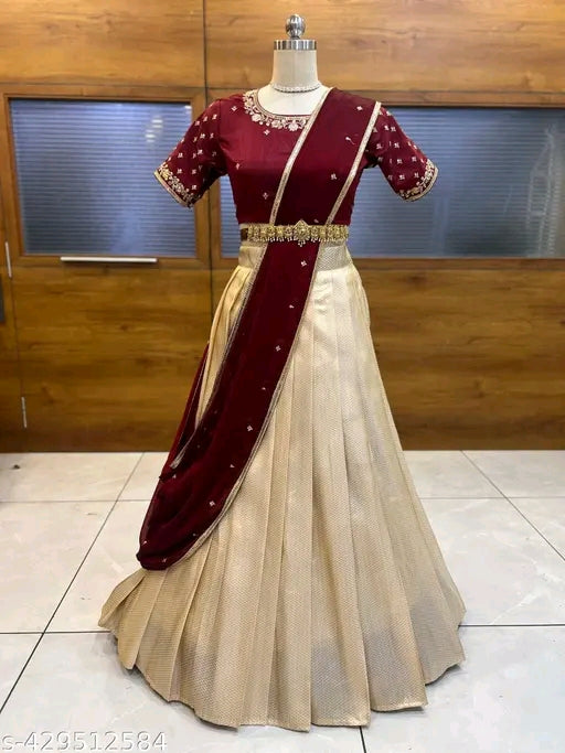 Maroon and beige saree on a mannequin against a wooden wall.
