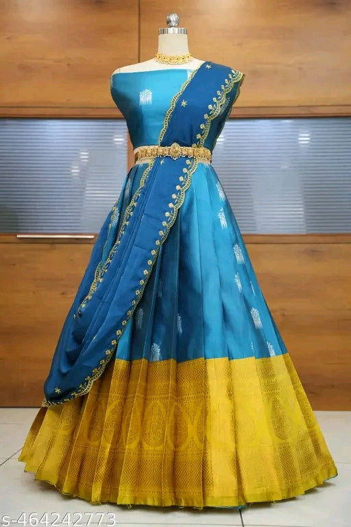 Blue and yellow traditional dress on a mannequin against a wooden wall.