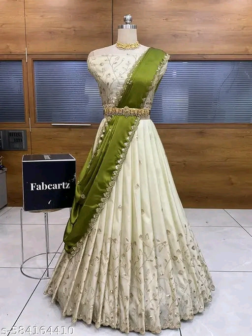 White and green embroidered dress on a mannequin with a Fabcartz box in the background.