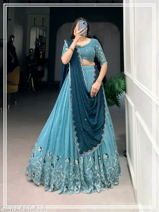 Woman in a blue traditional outfit with a matching dupatta taking a mirror selfie.