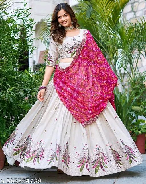 Woman wearing a white and pink traditional outfit with a floral pattern in an outdoor setting.