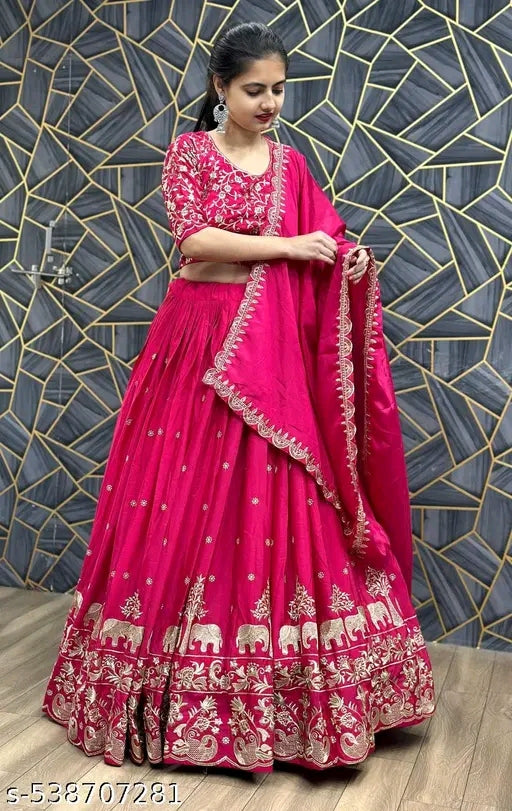 Woman in a pink embroidered traditional outfit against a geometric patterned wall.