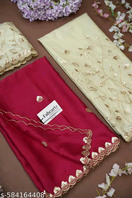 Red fabric with gold embroidery and a visible brand label on a brown surface with decorative flowers.