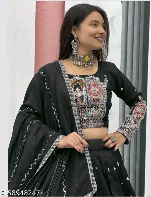 Woman wearing a black traditional outfit with intricate embroidery and jewelry.