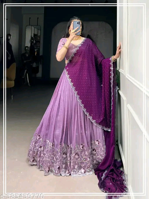 Person wearing a purple saree with a matching blouse in a room.