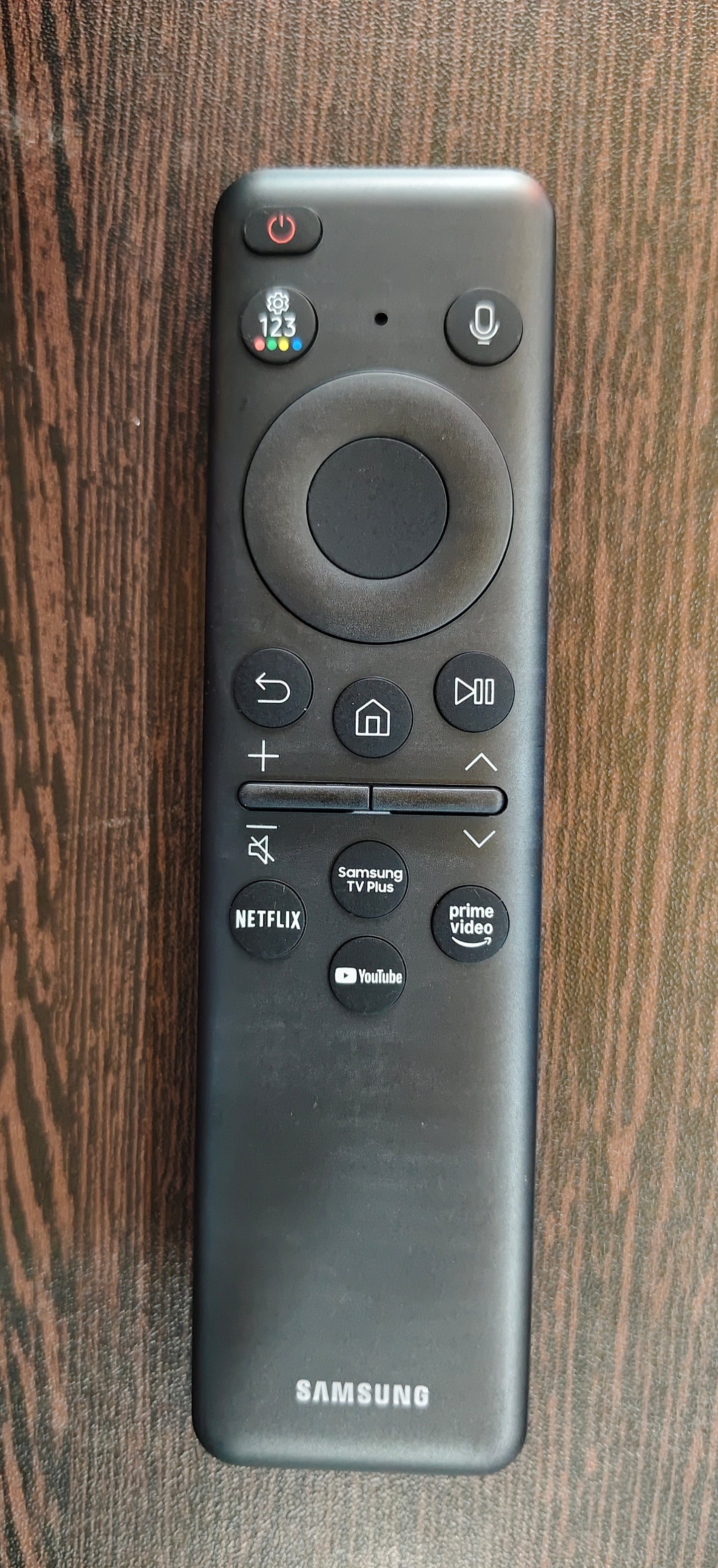 Samsung remote control on a wooden surface