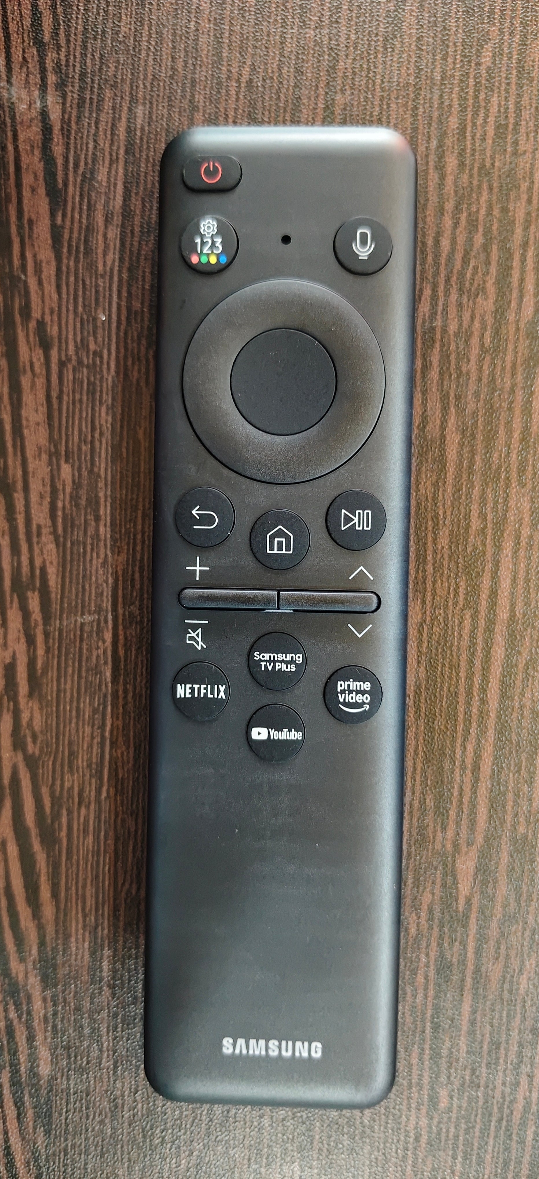 Samsung remote control on a wooden surface