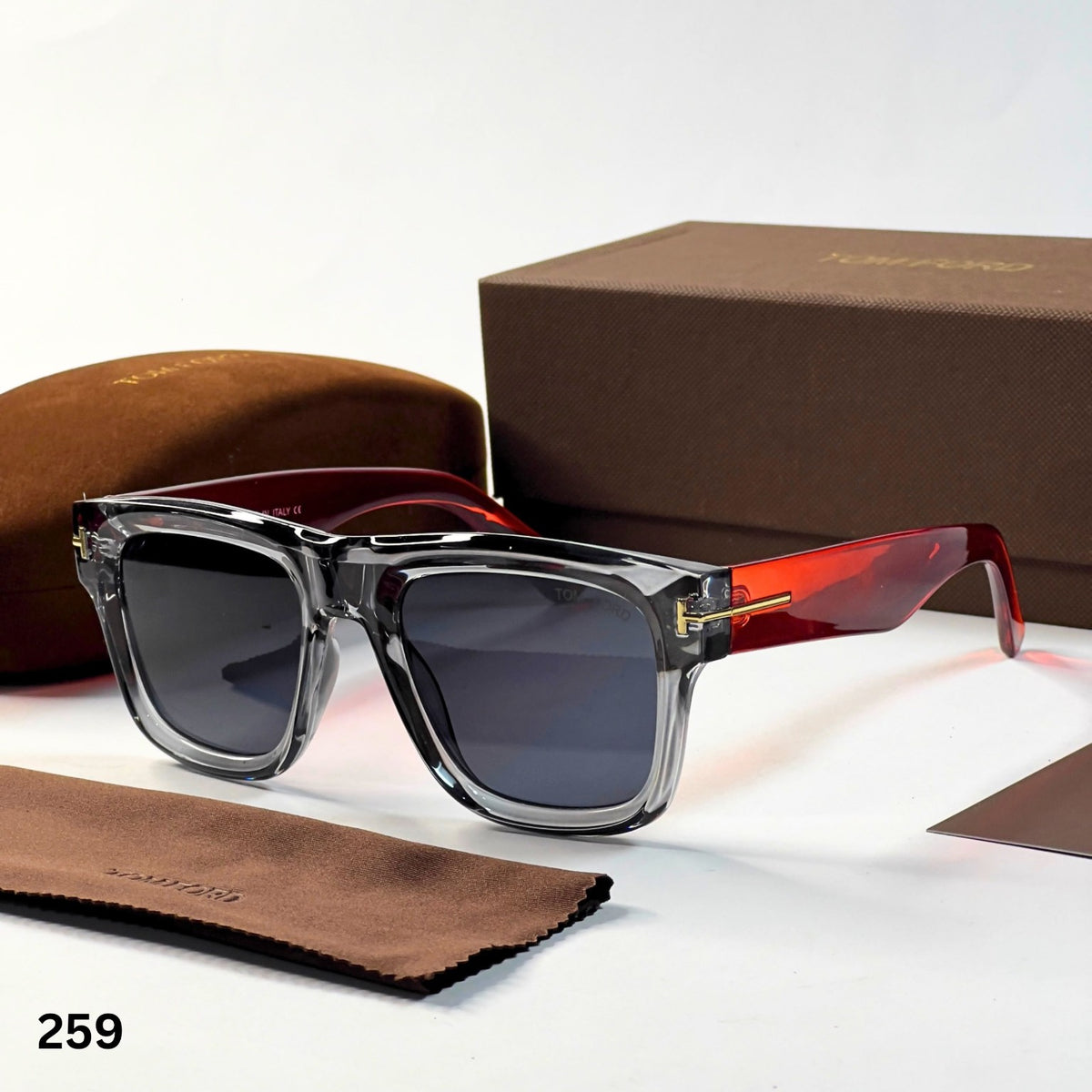 Tom Ford 259 sunglasses with transparent grey frame, dark lenses and orange-red temples