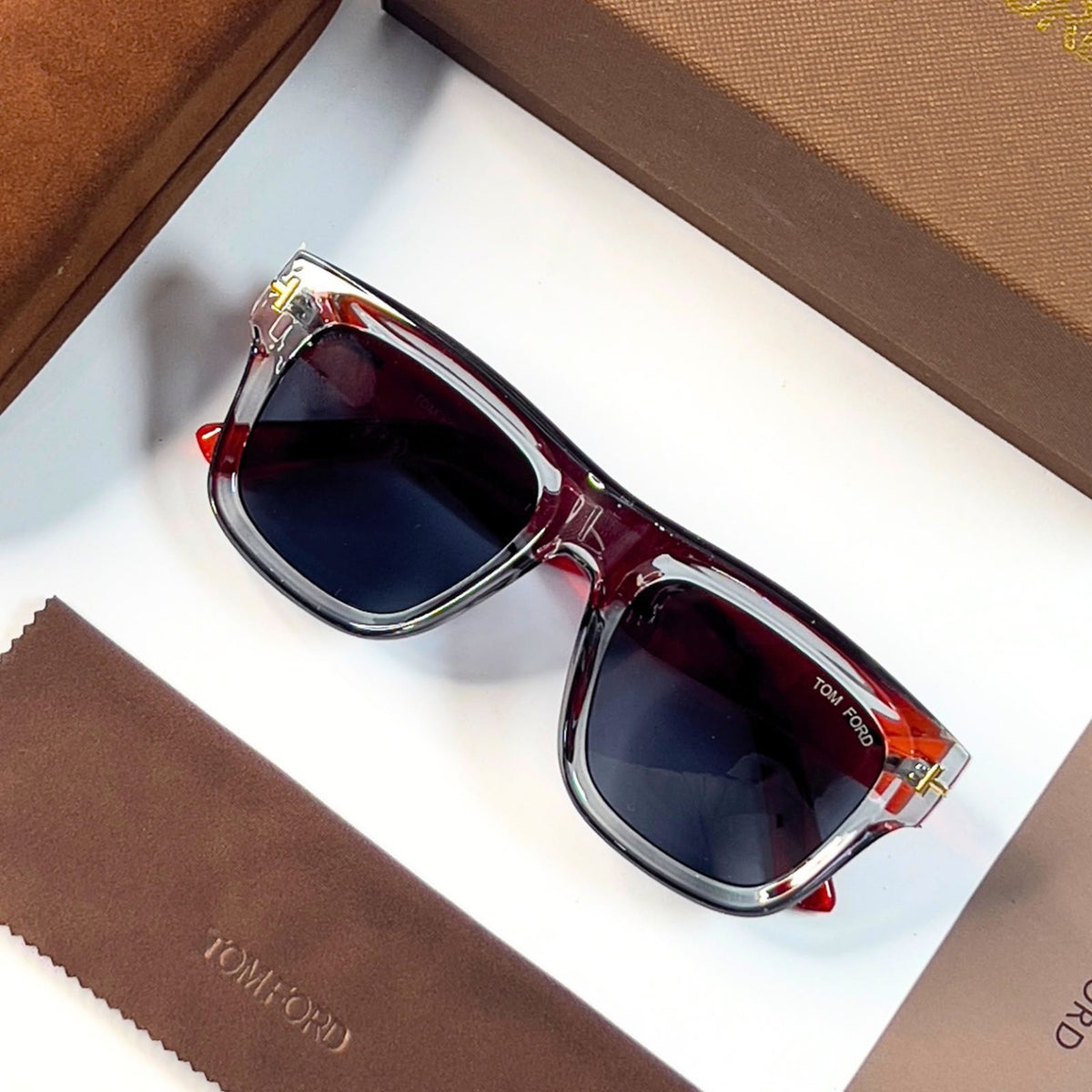Tom Ford 259 sunglasses with dark lenses and transparent grey and orange-red frame